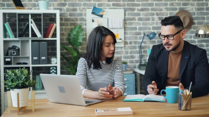 A financial planner talking through a plan with a client at a desk