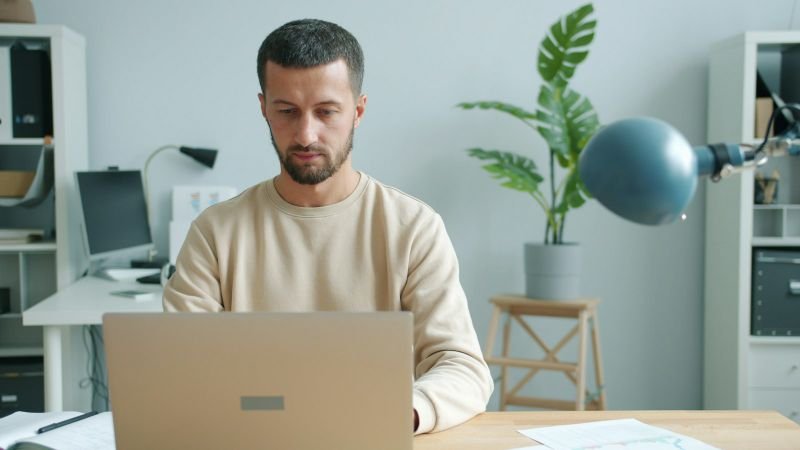 A man reviewing loan options on his laptop at his desk